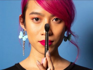 Gender expansive person with makeup brush